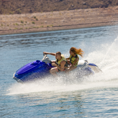 Couple ride a jet ski on a lake