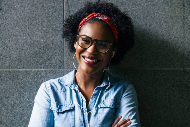 istock Smiling young African woman standing against a wall 833212604