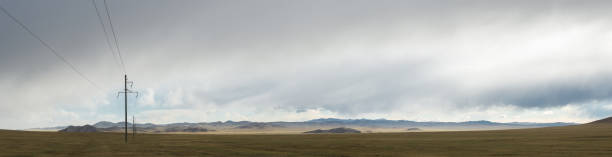 istock Electric power transmission pylons on grassland 833217398