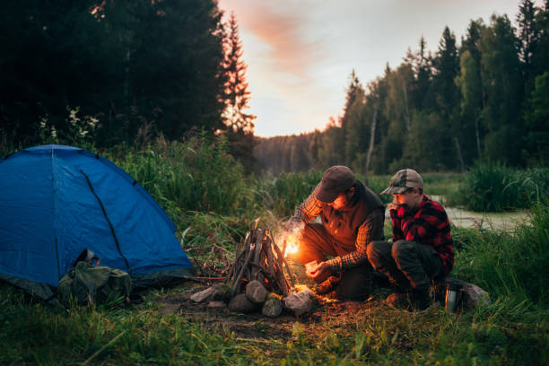 pai e filho acampar juntos - bonfire people campfire men - fotografias e filmes do acervo