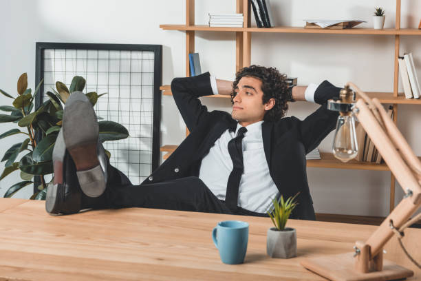 istock caucasian businessman with legs on table resting at workplace in office 833229820