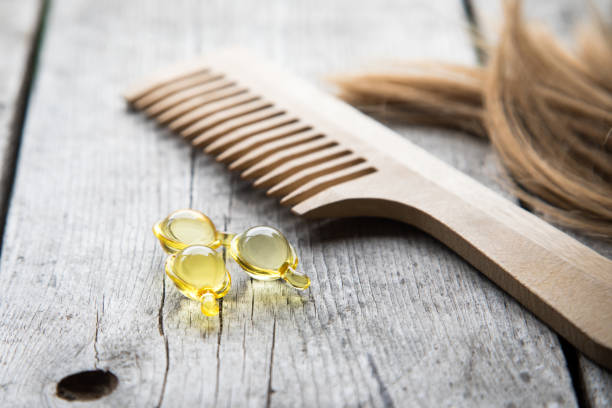 Hair nurishment. vitamin serum capsule on wooden background stock photo