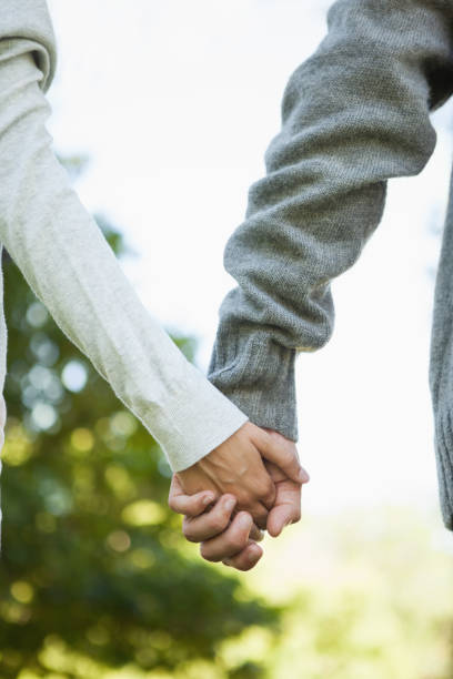 istock Cute couple holding hands in the park 833234478