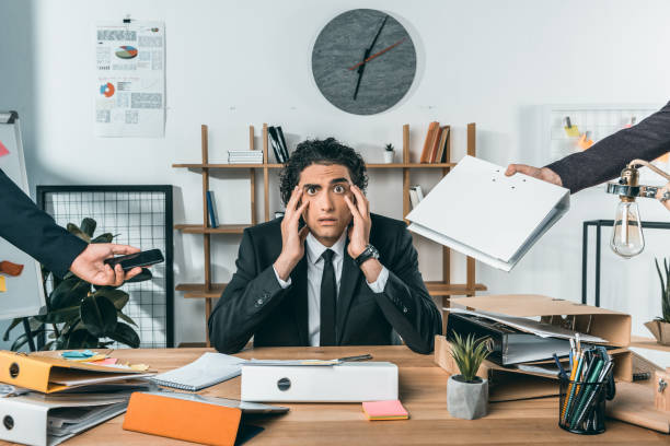 istock overworked businessman missing deadline due to work while colleagues pressing near by 833236662