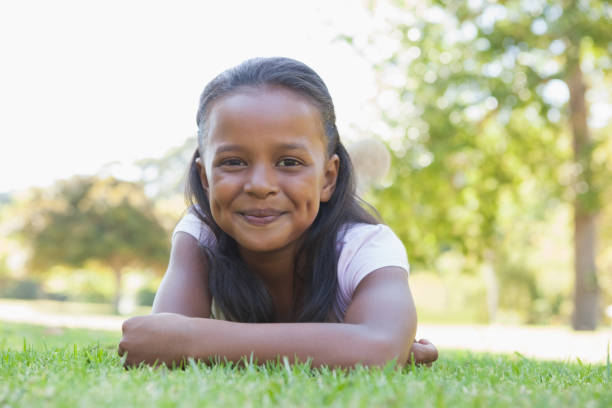 istock Little girl lying in the park smiling at camera 833237276