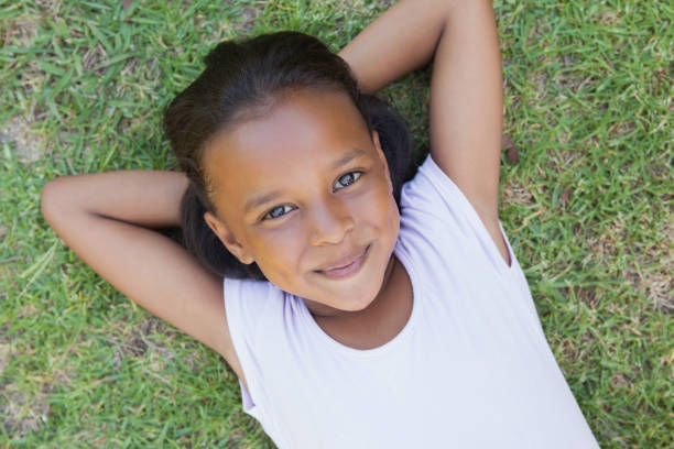 istock Little girl lying on the grass smiling at camera 833237436