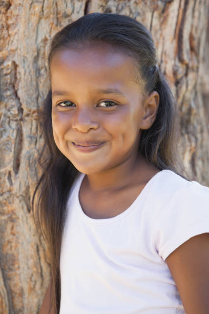 istock Little girl by large tree smiling at camera 833237626