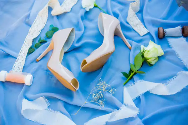 Wedding shoes. Footwear. Wedding accessories of the bride. Photo of a bride shoes on a blue background.
