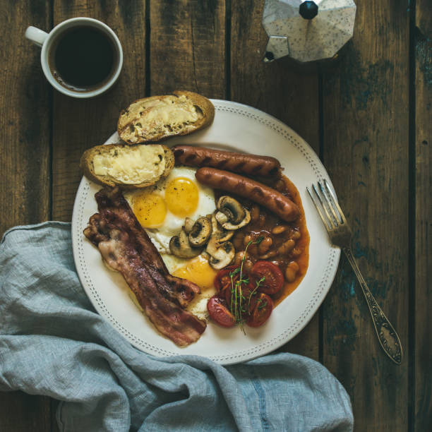istock Traditional English breakfast with fried eggs, sausages, mushrooms, bacon, coffee 833241014
