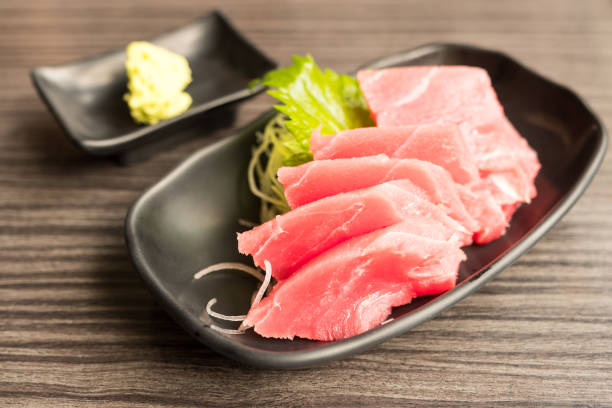 istock Tuna sashimi and wasabi in brown ceramic plate on wood table. 833241024