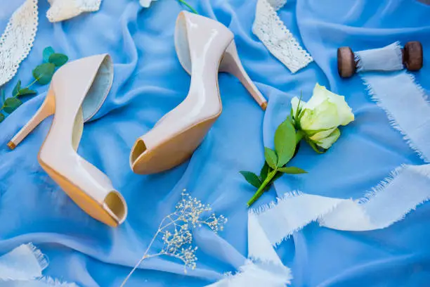 Wedding shoes. Footwear. Wedding accessories of the bride. Photo of a bride shoes on a blue background.