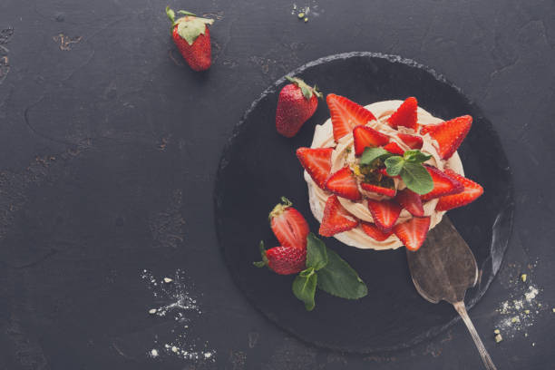 istock Anna Pavlova cake with strawberry on black background 833241916