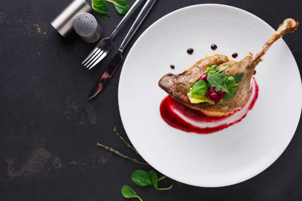 istock Restaurant meals. Duck confit with vegetables on black background 833246832