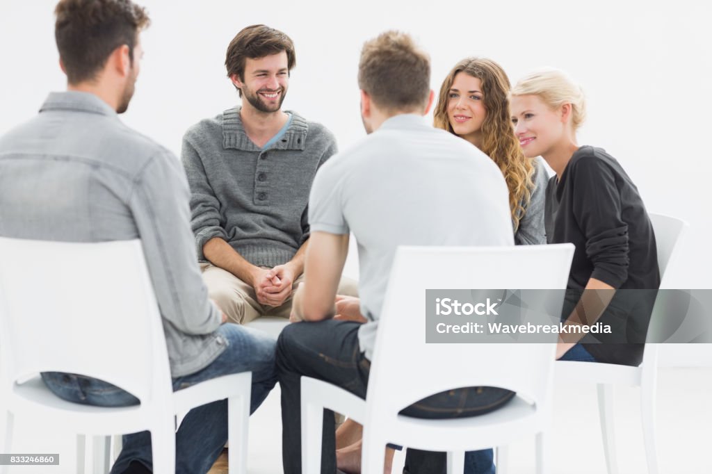 Group therapy in session sitting in a circle Group therapy in session sitting in a circle with therapist Focus Group Stock Photo