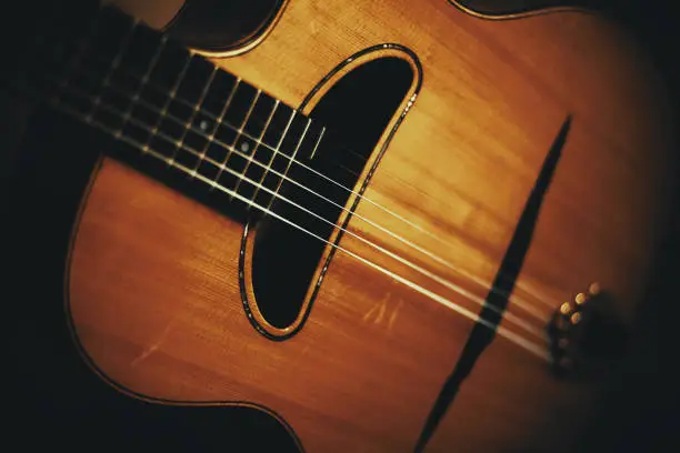 Closeup view of an old manouche acoustic guitar, vintage style.