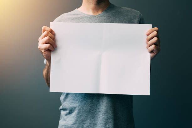 istock Man in gray t-shirt with blank paper 833252282
