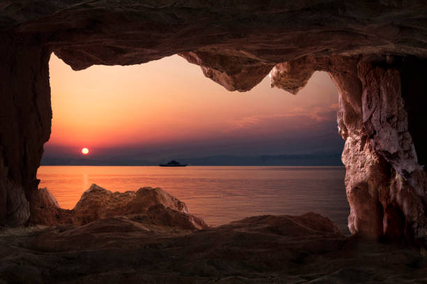 View of the sunset from the cave inside in Thasos, Greece View of the sunset from the cave inside in Thasos, Greece. cave stock pictures, royalty-free photos & images