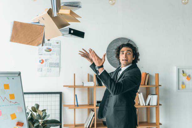 istock side view of young emotional businessman throwing folders with documents in office 833265322