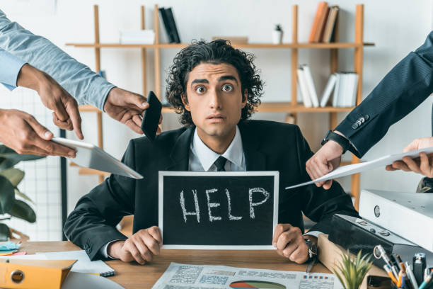 istock stressed businessman with help blackboard having troubles with deadline with colleagues standing near by 833265730