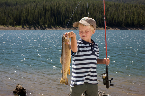 Boy fishing by the lake.