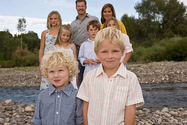 Brothers standing in front of family Brothers standing in front of family by river 4810 stock pictures, royalty-free photos & images