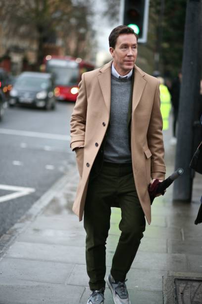 A Fashionable man attends London Collection Men fashion week in London A very stylish man wearing a camel  coloured coat taking a walk along a  London street during iLondon Collection Men. london fashion week stock pictures, royalty-free photos & images