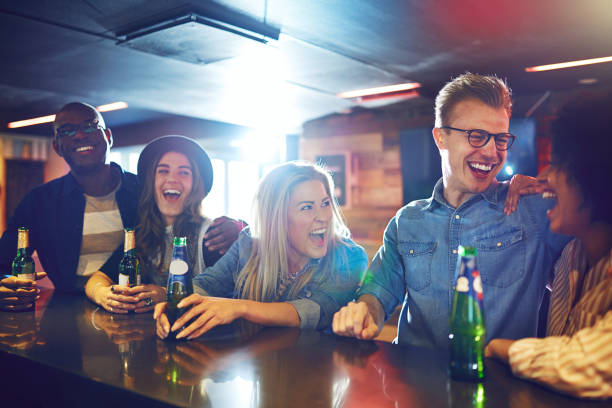 istock Laughing people sitting with drinks in bar 833296850