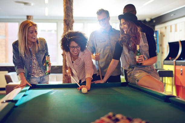 donna dietro la cue ball mentre gli amici guardano - pool game foto e immagini stock
