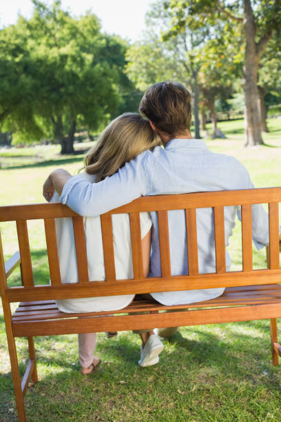 istock Couple relaxing on park bench together 833306900