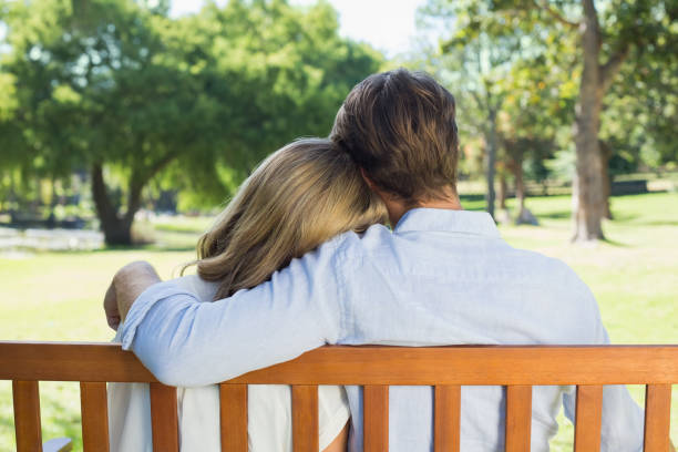 istock Affectionate couple relaxing on park bench together 833307368