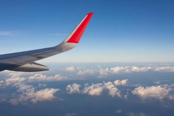 Photo of Wing of airplane flying above the clouds .