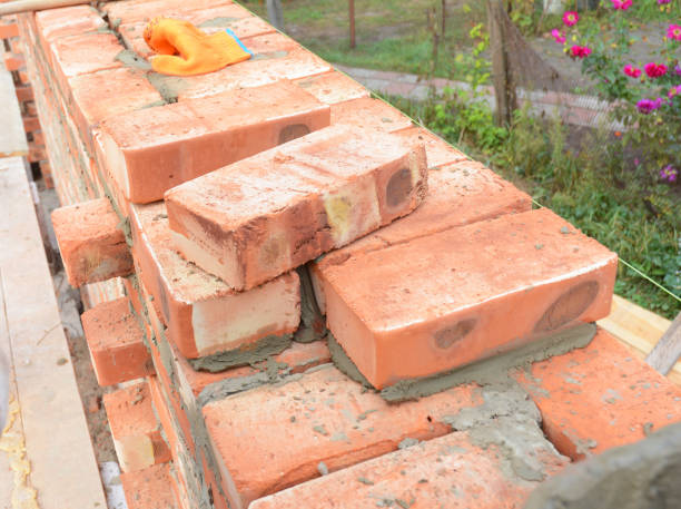 istock Bricklaying, Brickwork. Bricklaying on House Construction Site. Building Home wall from Bricks. Bricklayer Worker Installing Red Blocks and Caulking Brick Masonry Joints Exterior Wall. 833311172