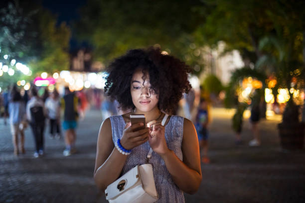 istock Woman walking and using smart phone on street 833313414