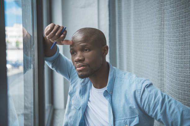 istock african american man looking at window 833320292