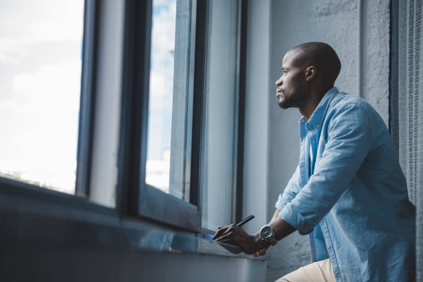 istock african american man looking at window 833320898