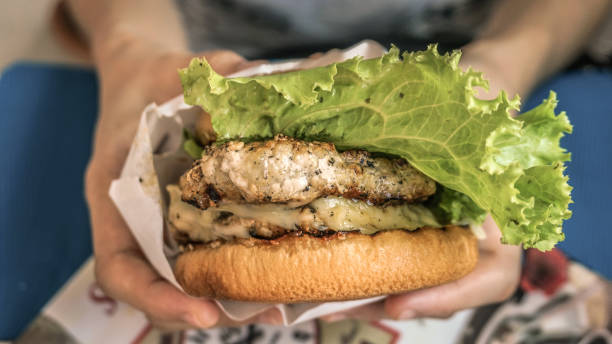 istock Hands squeeze big homdmade grilled pork burger 833333114