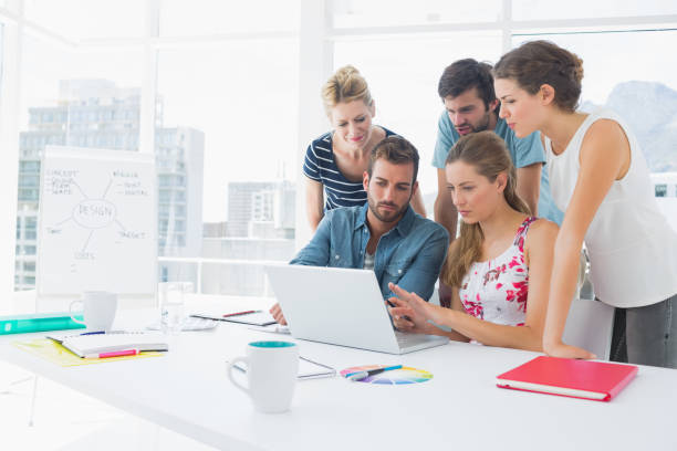 istock Casual business people using laptop together 833334840