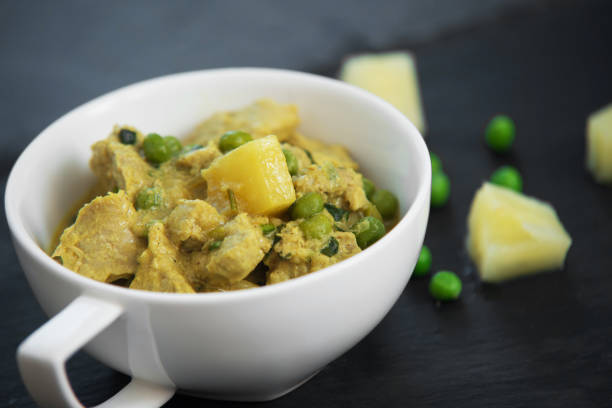 istock Pineapple, pea and pork stew on black stone background 833340846