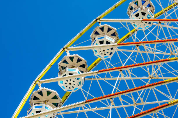 istock A Ferris wheel and its colorful passenger baskets against blue sky 833342396