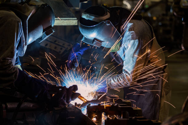 istock Industrial workers with protective mask are welding automotive part 833357102