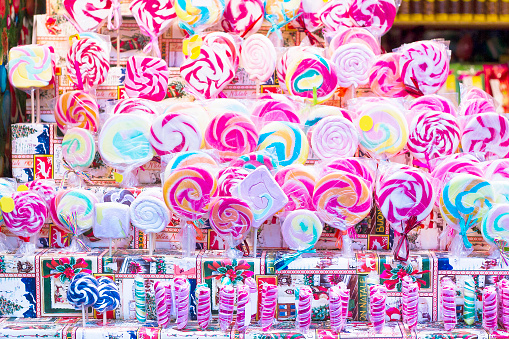 Great choice of colorful lollipops on stick for sale in shop window