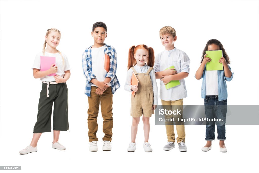 adorable multiethnic children holding textbooks and smiling at camera isolated on white White Background Stock Photo