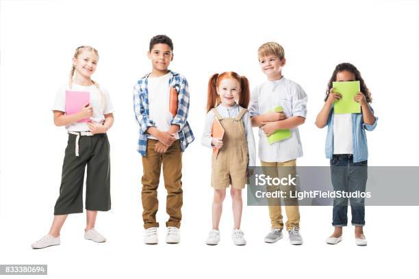 Adorable Multiethnic Children Holding Textbooks And Smiling At Camera Isolated On White Stock Photo - Download Image Now