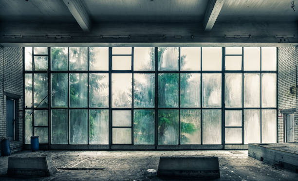 widok ze starej, opuszczonej fabryki od wewnątrz z ładnym świat�łem okiennym - abandoned factory warehouse dark zdjęcia i obrazy z banku zdjęć