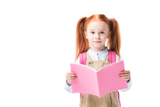 istock Adorable smiling schoolgirl reading textbook isolated on white 833387202