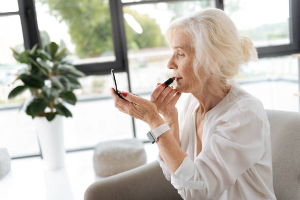 istock Pleasant good looking woman using a lipstick 833396256