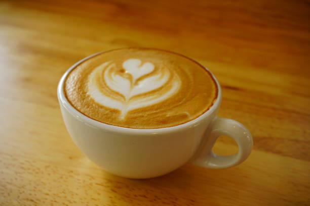 istock Cup of hot latte art coffee on wooden table 833403692
