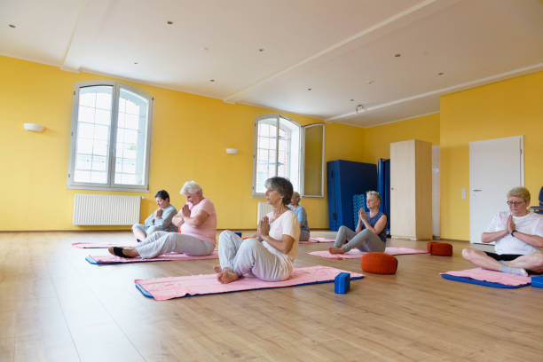 istock Senior women in yoga class practicing meditation 833443588