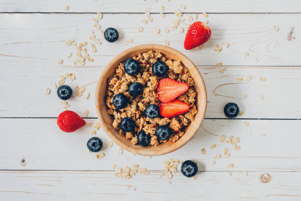 istock Homemade granola and fresh berries on wood table with space. 833482066
