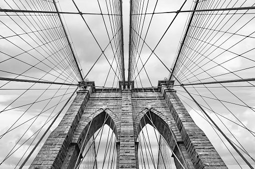 NEW YORK, USA - May 05, 2016: Black and white image of Brooklyn bridge in New York City against sky with clouds